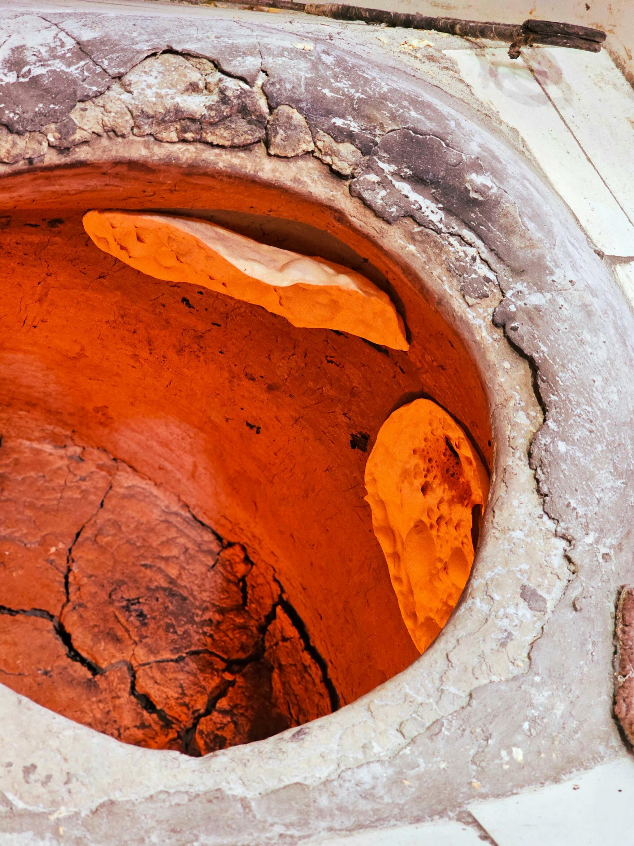 Naan baking inside a traditional Iranian tandoor oven